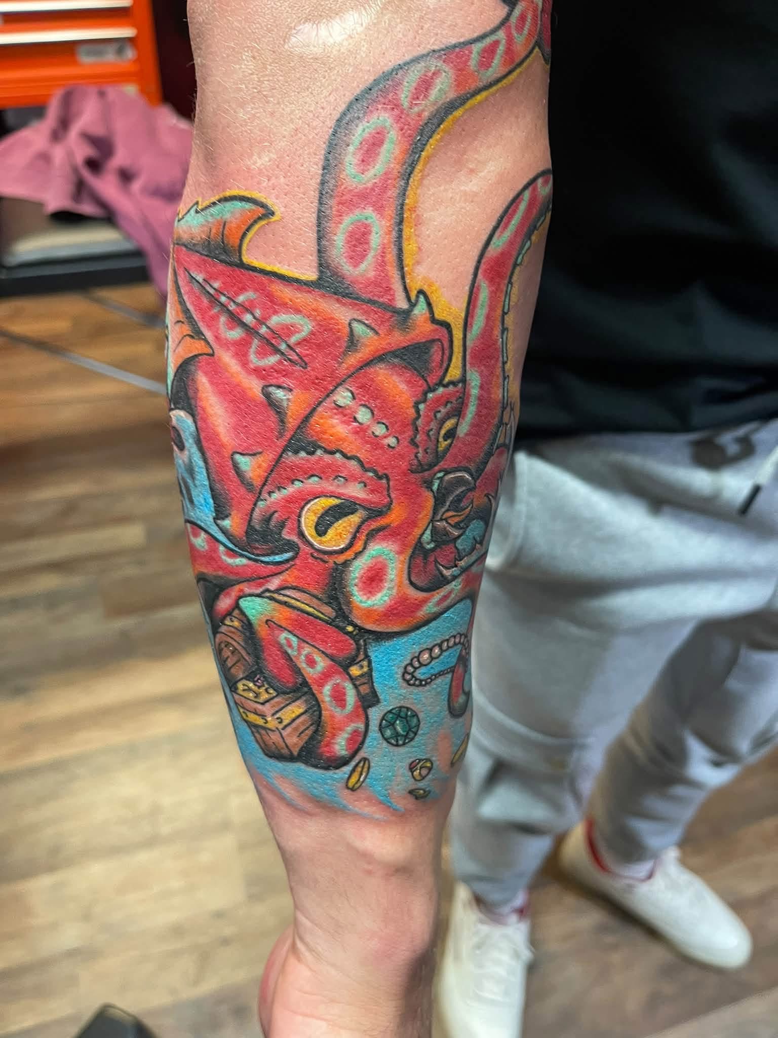 Red octopus and treasure chest tattoo